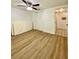 Bedroom with laminate flooring, a ceiling fan, a closet, and access to a bathroom at 3325 Honeymoon Ln, Holiday, FL 34691