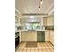Bright kitchen featuring white cabinets, light countertops, tile floors, and a view into the yard at 3325 Honeymoon Ln, Holiday, FL 34691