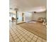 Spacious living room with tile and wood flooring, ceiling fan, and sliding glass doors to the outdoor patio at 3325 Honeymoon Ln, Holiday, FL 34691