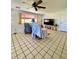 Inviting living room featuring tile floors, wainscoting, and large window providing natural light at 3325 Honeymoon Ln, Holiday, FL 34691
