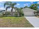Charming single-story home with manicured lawn, mature palms, and a two-car garage at 3370 Harbor Lake Dr, Largo, FL 33770