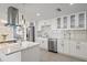 Bright and modern kitchen featuring white cabinets, stainless steel appliances, and stylish pendant lighting at 3370 Harbor Lake Dr, Largo, FL 33770