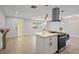Modern open-concept kitchen with an island, stainless steel appliances, and tile flooring throughout the home at 3370 Harbor Lake Dr, Largo, FL 33770