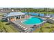 Aerial view of a community pool and pool house overlooking a small body of water and homes at 4312 112Th E St, Palmetto, FL 34221