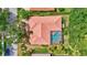 Overhead shot of a property with a tile roof, screened-in pool area, and lush greenery at 4730 Old Farm Rd, Sarasota, FL 34233