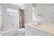 Bright bathroom featuring a shower/tub, neutral tiles, a floral shower curtain and an adjacent sink at 4730 Old Farm Rd, Sarasota, FL 34233