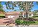 Charming single-story home featuring a tile roof, brick driveway, and mature landscaping at 4730 Old Farm Rd, Sarasota, FL 34233
