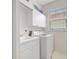 Bright laundry room featuring a washing machine, sink and white cabinets with a window that brings in natural light at 4730 Old Farm Rd, Sarasota, FL 34233