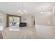 Spacious open-plan living room featuring tile floors, sliders to the lanai and pool, and views of the adjacent dining room at 4730 Old Farm Rd, Sarasota, FL 34233
