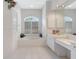 Bright main bathroom with a soaking tub, white cabinetry, and a vanity area at 4730 Old Farm Rd, Sarasota, FL 34233