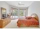 Cozy main bedroom featuring access to the screened-in lanai and views of the pool at 4730 Old Farm Rd, Sarasota, FL 34233
