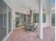 Covered patio with brick pavers and a table set, overlooking the screened pool area at 4730 Old Farm Rd, Sarasota, FL 34233