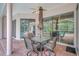 Covered patio with brick pavers and a table set, overlooking the screened pool area at 4730 Old Farm Rd, Sarasota, FL 34233