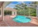 Beautiful in-ground screened pool and spa with brick paver deck and surrounding greenery at 4730 Old Farm Rd, Sarasota, FL 34233