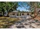 Charming single-story home featuring a classic white facade surrounded by mature trees and a driveway at 4918 Lahaina Dr, Sarasota, FL 34232