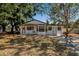 Charming single-story home featuring a classic white facade surrounded by mature trees at 4918 Lahaina Dr, Sarasota, FL 34232