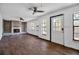 Spacious living room with a brick fireplace, ceiling fan, hardwood floors and abundant natural light from multiple windows at 4918 Lahaina Dr, Sarasota, FL 34232
