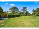 View of a spacious backyard with green grass and privacy hedges at 5603 Ravenwood Dr, Sarasota, FL 34243