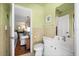 Bright bathroom featuring a white vanity, toilet, and classic tiling, with a glimpse into the living space at 5603 Ravenwood Dr, Sarasota, FL 34243