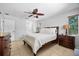 Cozy bedroom featuring a queen bed, ceiling fan, tiled floors, and classic wood furnishings at 5603 Ravenwood Dr, Sarasota, FL 34243