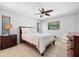 Comfortable bedroom with a queen bed, neutral decor, ceiling fan, and natural light from windows at 5603 Ravenwood Dr, Sarasota, FL 34243