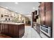 This gourmet kitchen features dark wood cabinets, an island, stainless appliances and granite countertops at 5603 Ravenwood Dr, Sarasota, FL 34243