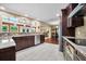 This spacious kitchen has stainless appliances, dark wood cabinets, granite counters, and a breakfast bar at 5603 Ravenwood Dr, Sarasota, FL 34243