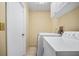 Functional laundry room with white washer and dryer units, neutral walls, and tiled floor at 5603 Ravenwood Dr, Sarasota, FL 34243