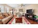 Relaxing living room featuring a large couch, hardwood flooring, and lots of natural light from the windows at 5603 Ravenwood Dr, Sarasota, FL 34243