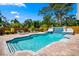 Pool with a waterfall feature, framed by lush greenery and lounge chairs, creating a relaxing oasis in the backyard at 5603 Ravenwood Dr, Sarasota, FL 34243