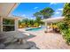 Backyard oasis showcasing a refreshing pool, waterfall feature, ample lounge space, and outdoor dining area at 5603 Ravenwood Dr, Sarasota, FL 34243
