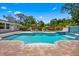 Inviting pool area featuring a waterfall, sun loungers, and a lush tropical backdrop for ultimate relaxation and enjoyment at 5603 Ravenwood Dr, Sarasota, FL 34243