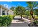 A beautifully designed brick walkway surrounded by lush tropical vegetation adds a touch of elegance to the home's exterior at 5603 Ravenwood Dr, Sarasota, FL 34243