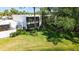 View of the back of condo with enclosed porch, lawn and landscaping at 564 Lakeside Dr # 564, Bradenton, FL 34210