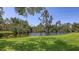 Lush backyard scene featuring a peaceful lake surrounded by vibrant green grass and trees at 564 Lakeside Dr # 564, Bradenton, FL 34210