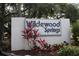 The 'Wildewood Springs' sign is set amid tropical landscaping, offering a warm community welcome at 564 Lakeside Dr # 564, Bradenton, FL 34210
