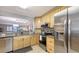 Well-lit kitchen with wood cabinets, granite countertops, stainless appliances, and open to living area at 564 Lakeside Dr # 564, Bradenton, FL 34210