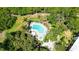 Aerial view of a kidney-shaped pool, jacuzzi and lounge chairs surrounded by lush landscaping and mature trees at 564 Lakeside Dr # 564, Bradenton, FL 34210