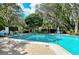 Outdoor pool with brick paver deck surrounded by lounge chairs, mature trees, and lush landscaping at 564 Lakeside Dr # 564, Bradenton, FL 34210