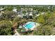 Aerial view of a long rectangular swimming pool surrounded by lush mature trees, landscaping and lounge chairs at 564 Lakeside Dr # 564, Bradenton, FL 34210