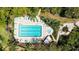 Aerial view of a rectangular swimming pool and jacuzzi with lounge chairs and lush landscaping and mature trees at 564 Lakeside Dr # 564, Bradenton, FL 34210