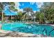 A community pool with lounge chairs, umbrellas, and lush landscaping creates an inviting outdoor retreat at 564 Lakeside Dr # 564, Bradenton, FL 34210