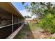 Scenic backyard view featuring a screened porch, wooden fence, and lush greenery at 5902 22Nd Avenue E Dr, Palmetto, FL 34221