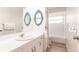Bright bathroom featuring dual blue-framed mirrors, white cabinets, and a shower/tub combo at 5902 22Nd Avenue E Dr, Palmetto, FL 34221