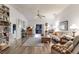 Bright living room featuring wood floors, a ceiling fan, comfortable seating, and an entertainment center at 5902 22Nd Avenue E Dr, Palmetto, FL 34221