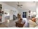 Cozy living room with a ceiling fan, wood floors, entertainment center, and view to bedroom at 5902 22Nd Avenue E Dr, Palmetto, FL 34221
