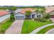 Beautiful single-story home with a lush front lawn, blue door and paver driveway at 5923 Snowy Egret Dr, Sarasota, FL 34238