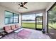 Screened lanai features brick pavers, ceiling fan, and a view of the lake and palm trees at 5923 Snowy Egret Dr, Sarasota, FL 34238