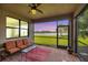 Screened-in patio with seating overlooking a scenic lake at 5923 Snowy Egret Dr, Sarasota, FL 34238