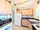 This is the kitchen with upper decorations, appliances, and an adjacent doorway at 5951 Todd St # D37, Bradenton, FL 34207